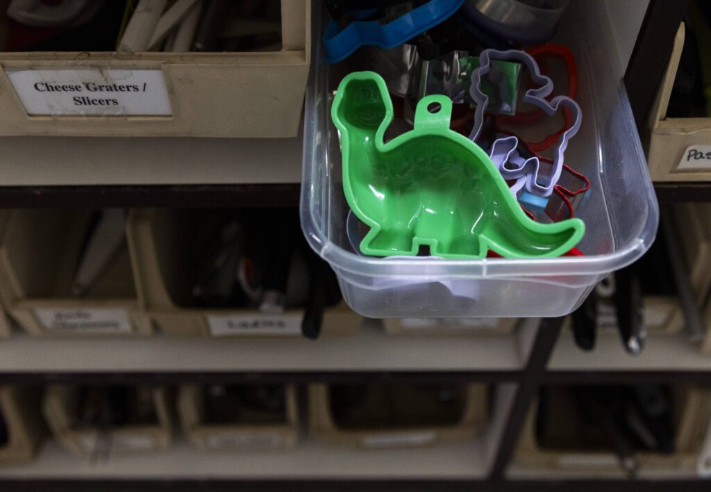 A green dinosaur cookie cutter sticks out of a drawer at the Good Cheer Thrift Store in Langley. (Olivia Vanni / The Herald)
