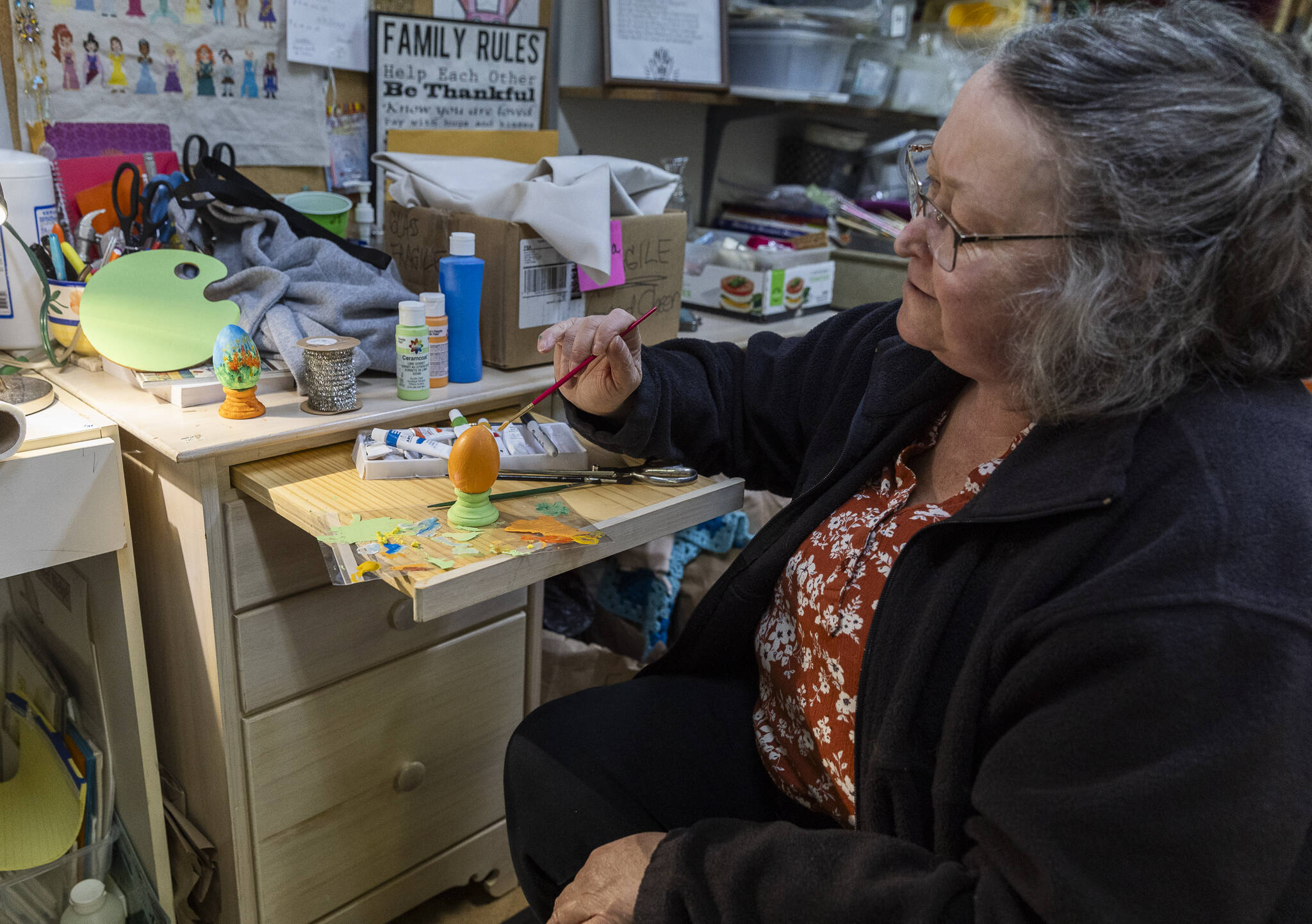 Sue Traher paints a wooden egg as an example for those who will be taking the crafts class offered at the Good Cheer Thrift Store in Langley. (Olivia Vanni / The Herald)