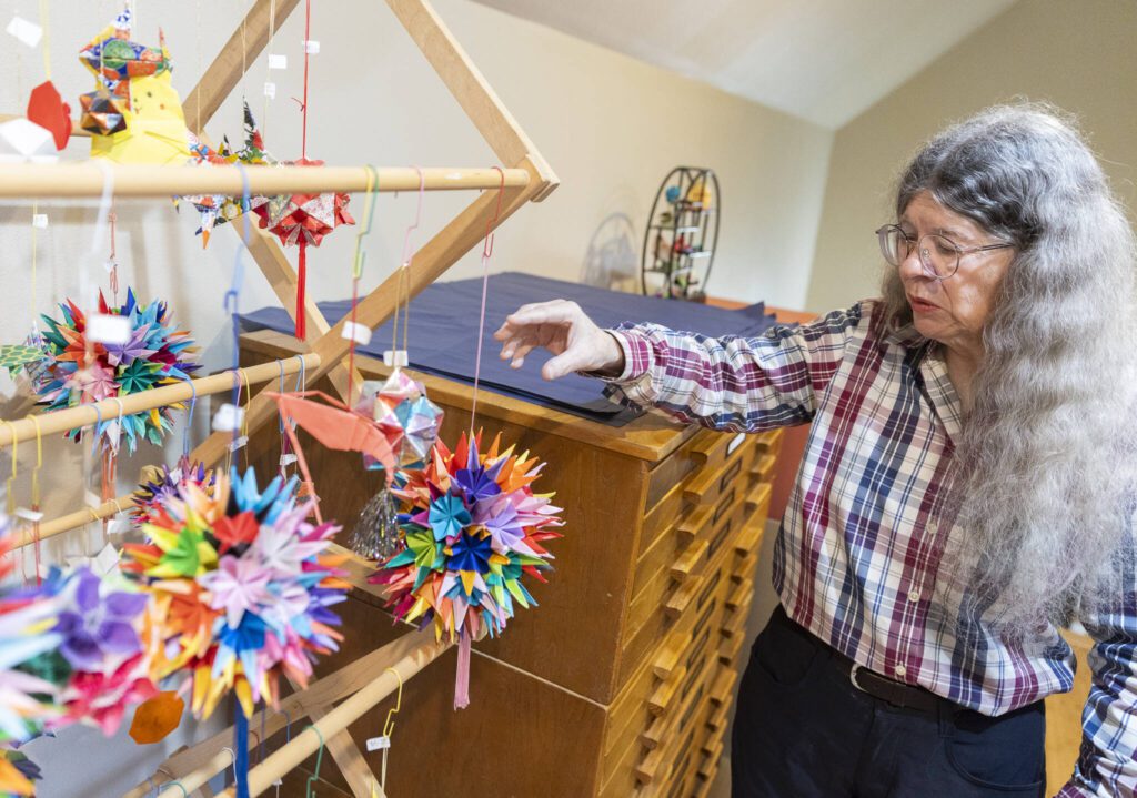 Kim Crane talks about a handful of origami items on display inside the Kim’s Crane showroom on Monday, Feb. 17, 2025, in Snohomish, Washington. (Olivia Vanni / The Herald)
