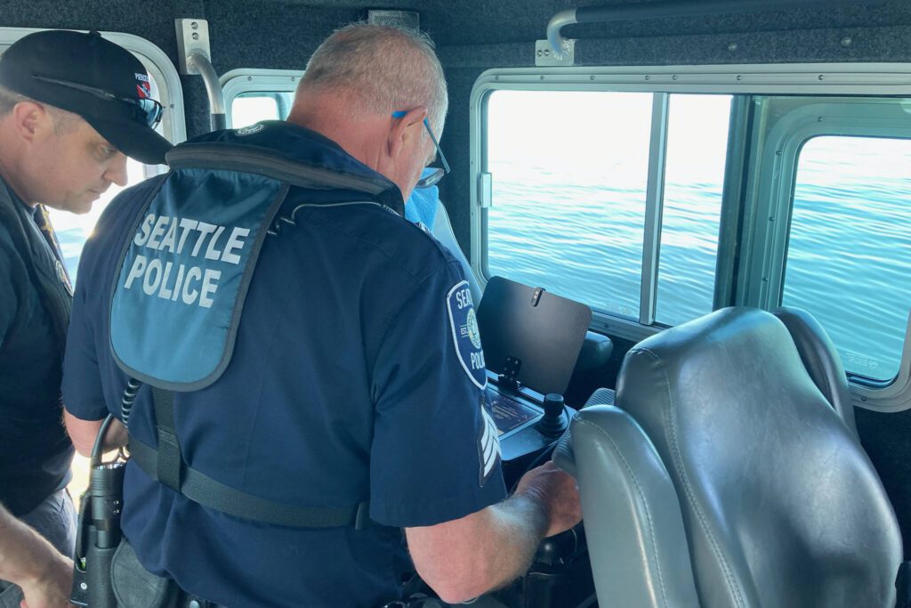 A Seattle police officer examines the submerged boat on Saturday, May 31, 2025, on Possession Sound near Everett, Washington. (Provided photo)

