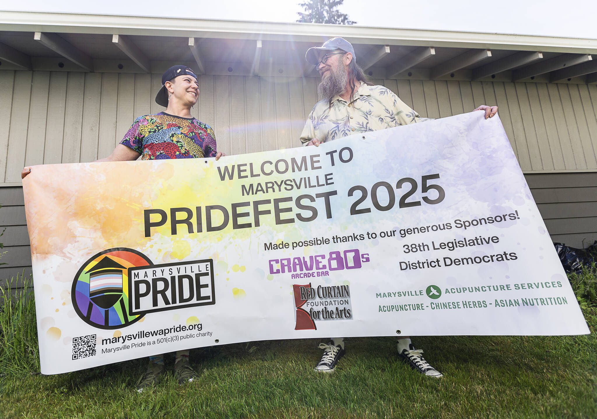 Marysville Pride organizers Vee Gilman, left, and Mike Pieckiel hold their welcome banner on Thursday, June 5, 2025 in Marysville, Washington. (Olivia Vanni / The Herald)