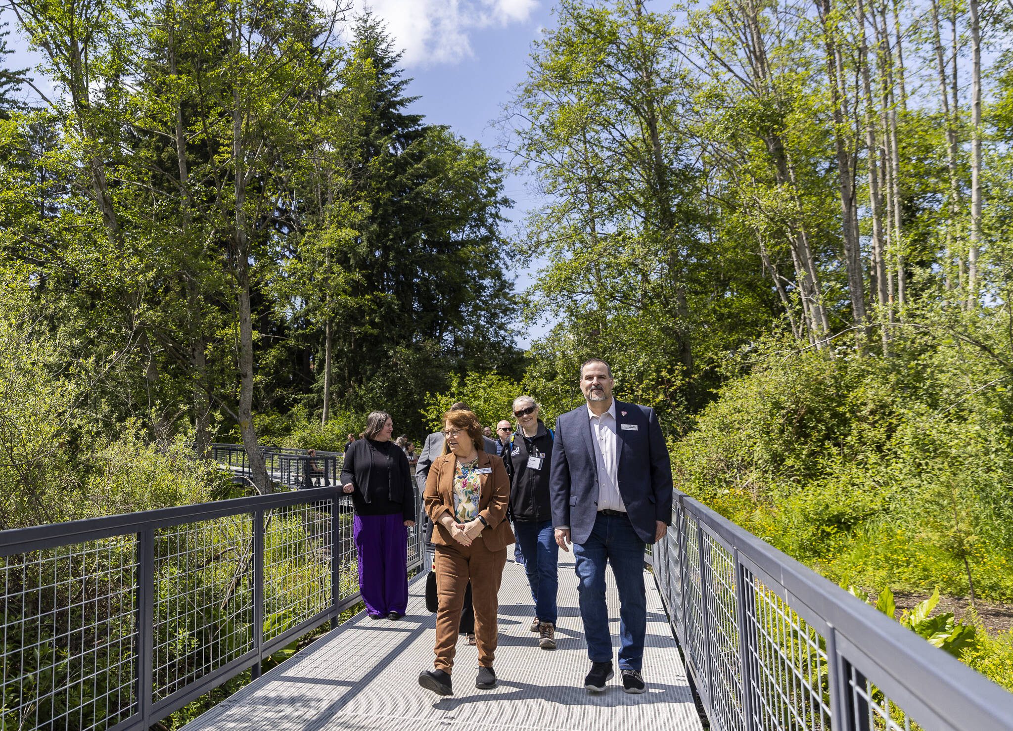 Lynnwood Mayor Christine Frizzell and Lynnwood City Council Member David Parshall along with others involved in the renovation of Scriber Lake Park explore the new boardwalk on Wednesday, June 4, 2025 in Lynnwood, Washington. (Olivia Vanni / The Herald)