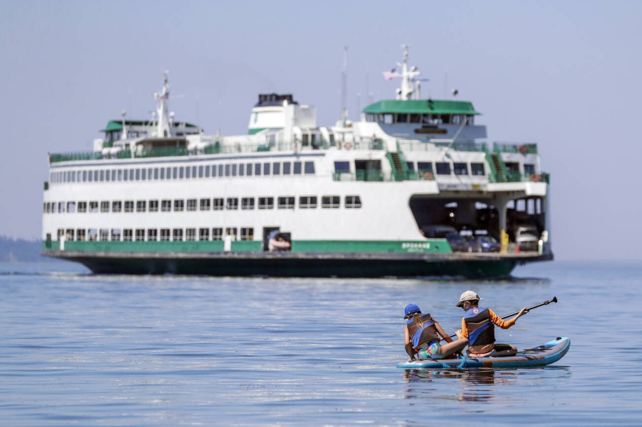 Paddle boarders enjoy the waters off Edmonds Beach last month to beat the heat in Edmonds, Washington on July 26, 2022.  (Kevin Clark / The Herald)
