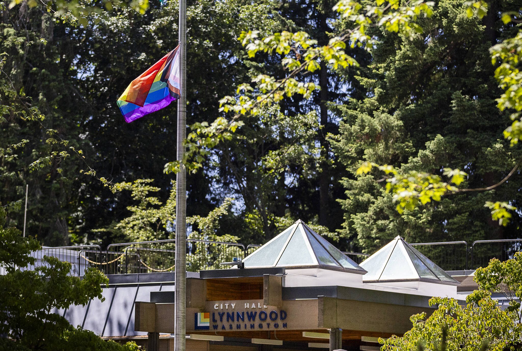 A rainbow LGBTQ+ pride flag hanging from a flag pole outside of Lynnwood City Hall moves in the wind on Tuesday in Lynnwood. (Olivia Vanni / The Herald)
