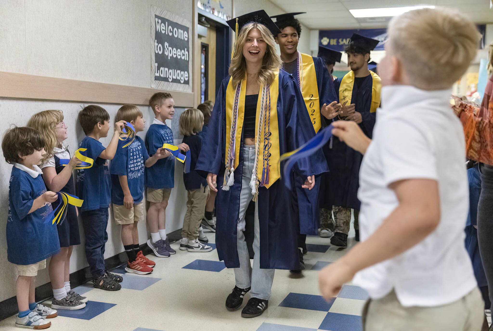 Everett High School graduate Gwen Bundy high fives students at her former grade school Whittier Elementary during their grad walk on Thursday, June 12, 2025 in Everett, Washington. (Olivia Vanni / The Herald)