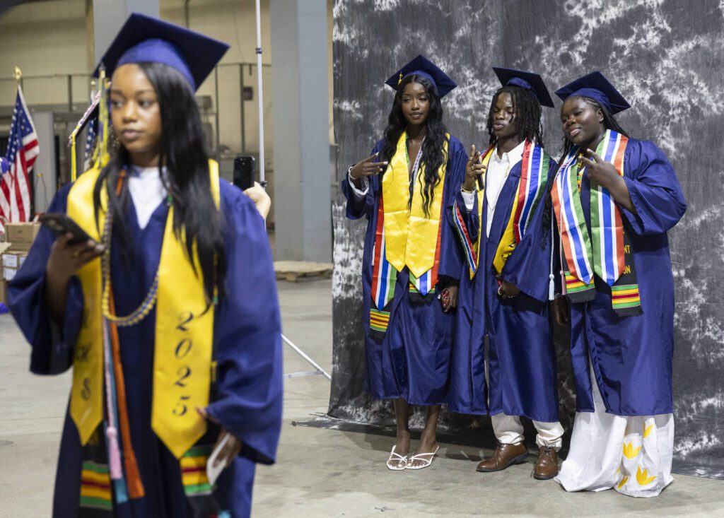 Jalika Kunjo, left, Ral Kanu, center, and Kaddijatou Jawara, right, takes photos before the start of Mariner High School’s 2025 commencement on Friday, June 13, 2025, at Angel of the Winds Arena in Everett, Washington. (Olivia Vanni / The Herald)
