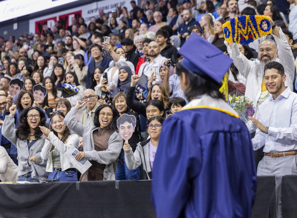 The family and friends of Maximus Trias jump and yell as he walks by on the way to his seat during Mariner High School’s 2025 commencement on Friday, June 13, 2025, at Angel of the Winds Arena in Everett, Washington. (Olivia Vanni / The Herald)
