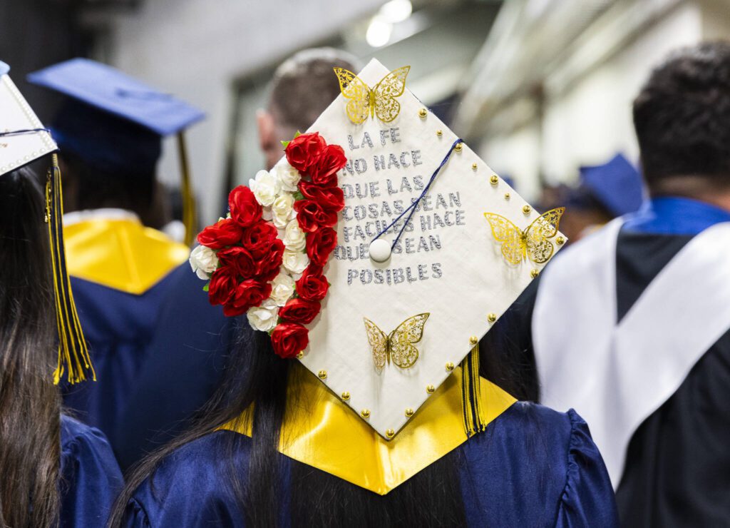 A graduation cap decorated with the words, “la fe no hace que las cosas sean facilies hace que sean posibles” or “faith doesn’t make things easy it makes them possible” is worn by a graduate during Mariner High School’s 2025 commencement on Friday, June 13, 2025, at Angel of the Winds Arena in Everett, Washington. (Olivia Vanni / The Herald)
