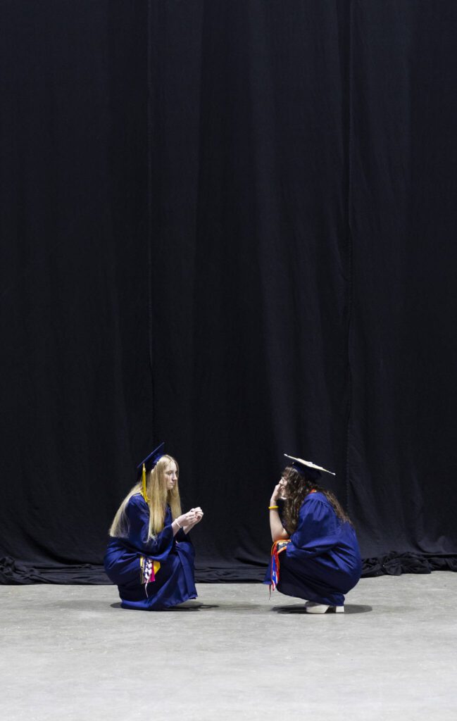 Graduates sit and talk backstage before the start of Mariner High School’s 2025 commencement on Friday, June 13, 2025, at Angel of the Winds Arena in Everett, Washington. (Olivia Vanni / The Herald)
