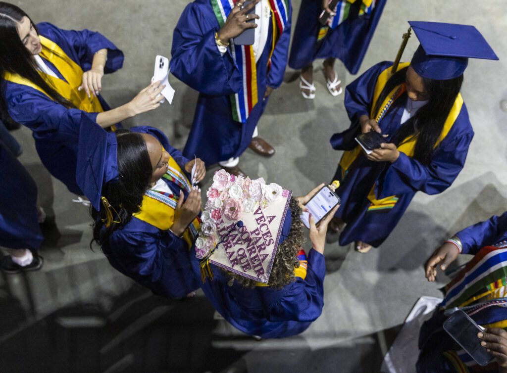Graduates take photos and text backstage before the start of Mariner High School’s 2025 commencement on Friday, June 13, 2025, at Angel of the Winds Arena in Everett, Washington. (Olivia Vanni / The Herald)
