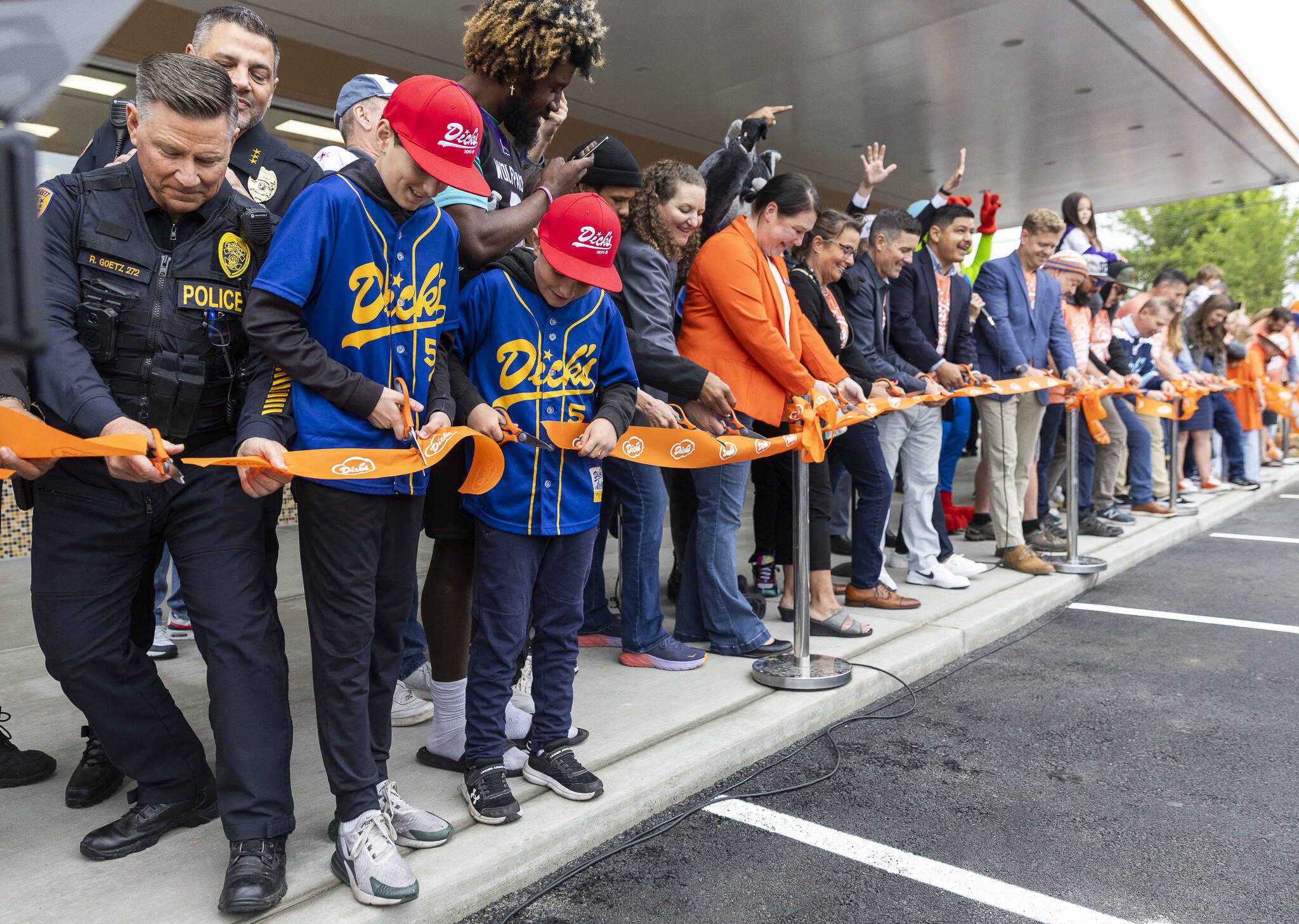 The great-grandsons of Dick’s Drive-In co-founder Dick Spady, James Donovan, 12, left, and brother Robert Donovan, 9, cut the ribbon for the grand opening of the Everett location while wearing matching Dick’s baseball jerseys on Thursday, June 12, 2025 in Everett, Washington. (Olivia Vanni / The Herald)
