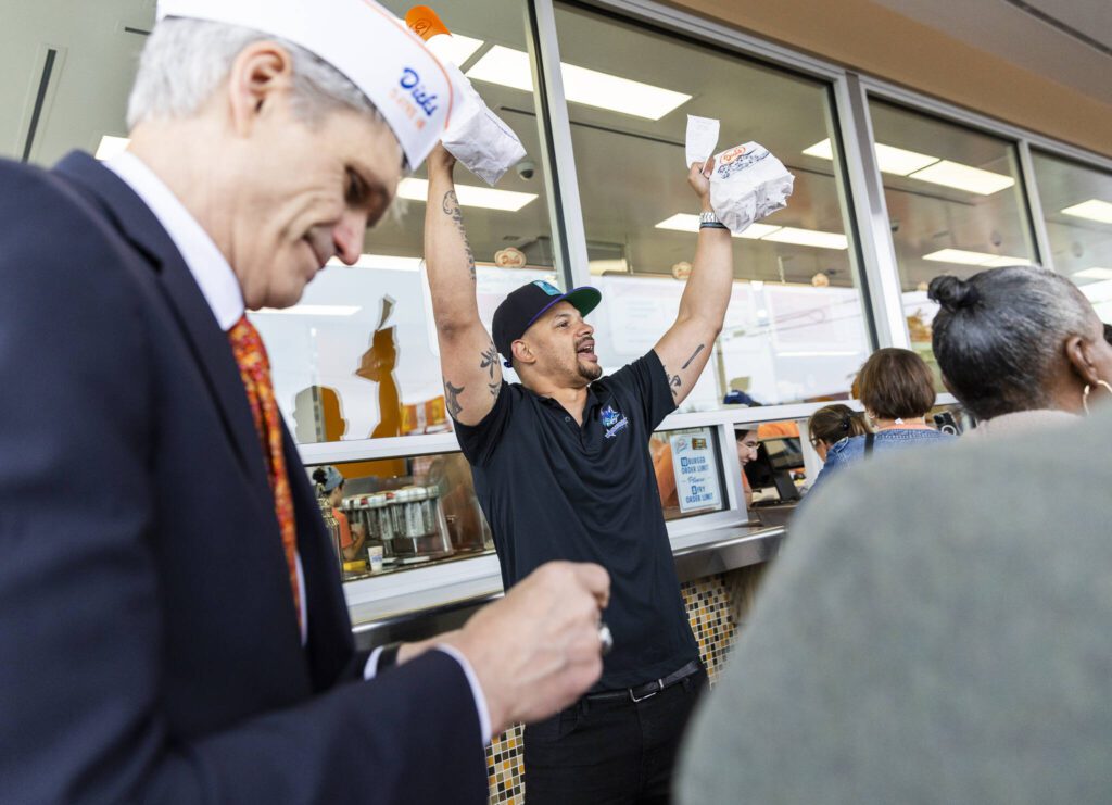 Everett Wolfpack head coach JR Wells yells in celebration after being one of the first five customers at the grand opening of the Dick’s Drive-In location in Everett on Thursday, June 12, 2025 in Everett, Washington. (Olivia Vanni / The Herald)
