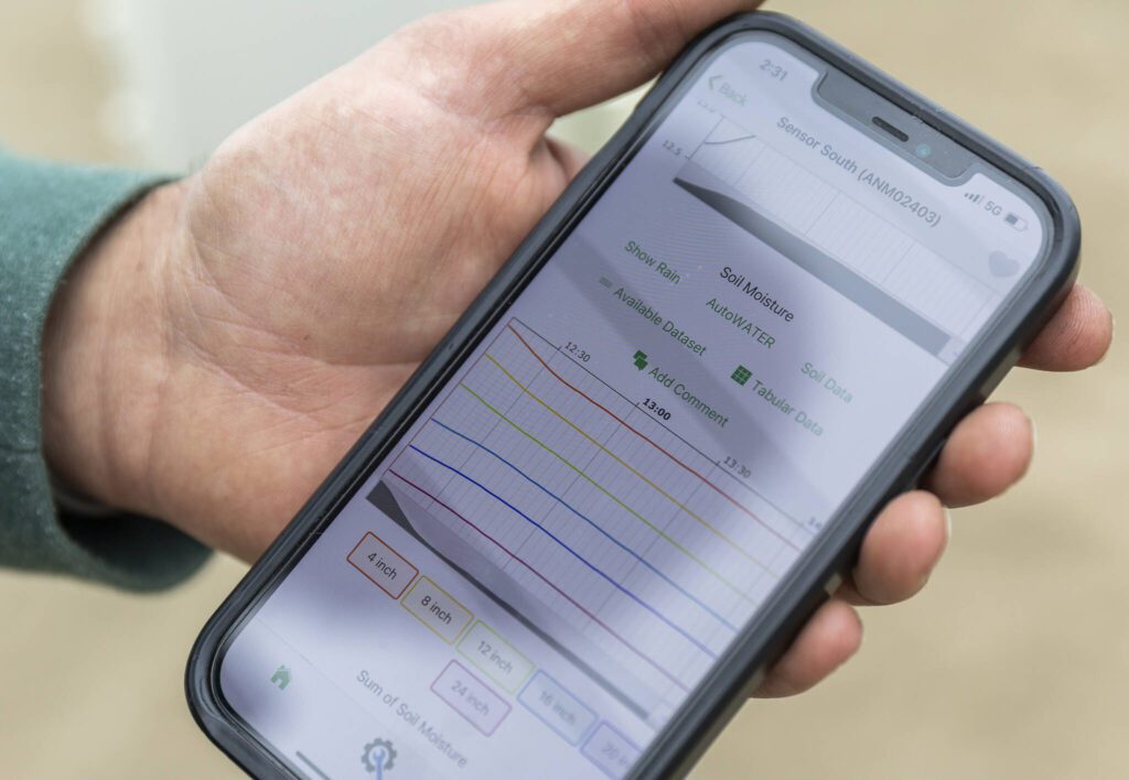 Simon Fuentes shows the in-app data available from the soil probe on Friday, June 13, 2025 in Snohomish, Washington. (Olivia Vanni / The Herald) 
