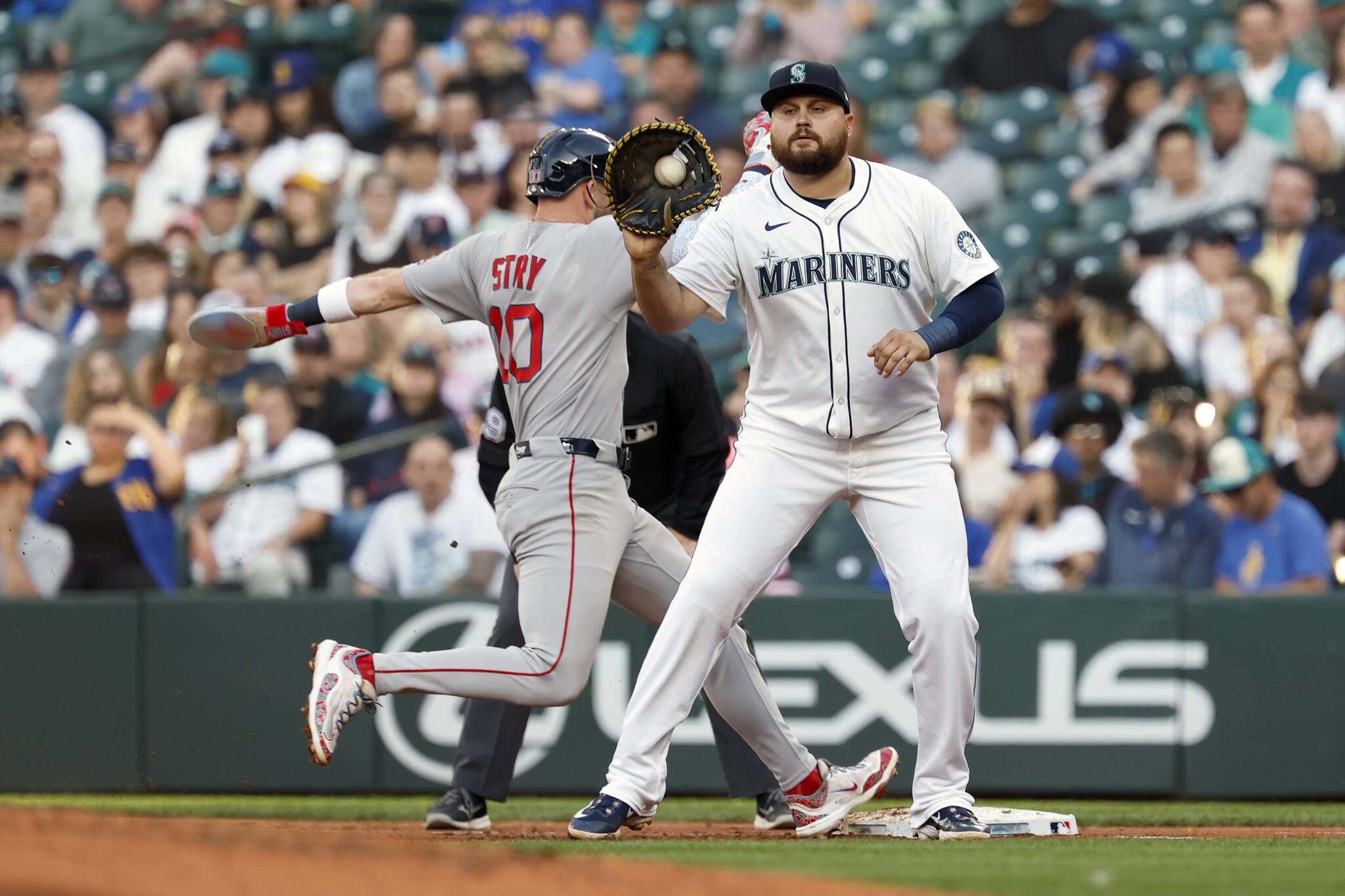 Trevor Story (10) of the Boston Red Sox safely jumps back to first base against Rowdy Tellez (23) of the Seattle Mariners during the fourth inning at T-Mobile Park on June 16, 2025 in Seattle, Washington. (Alika Jenner / Getty Images / Tribune News Services)