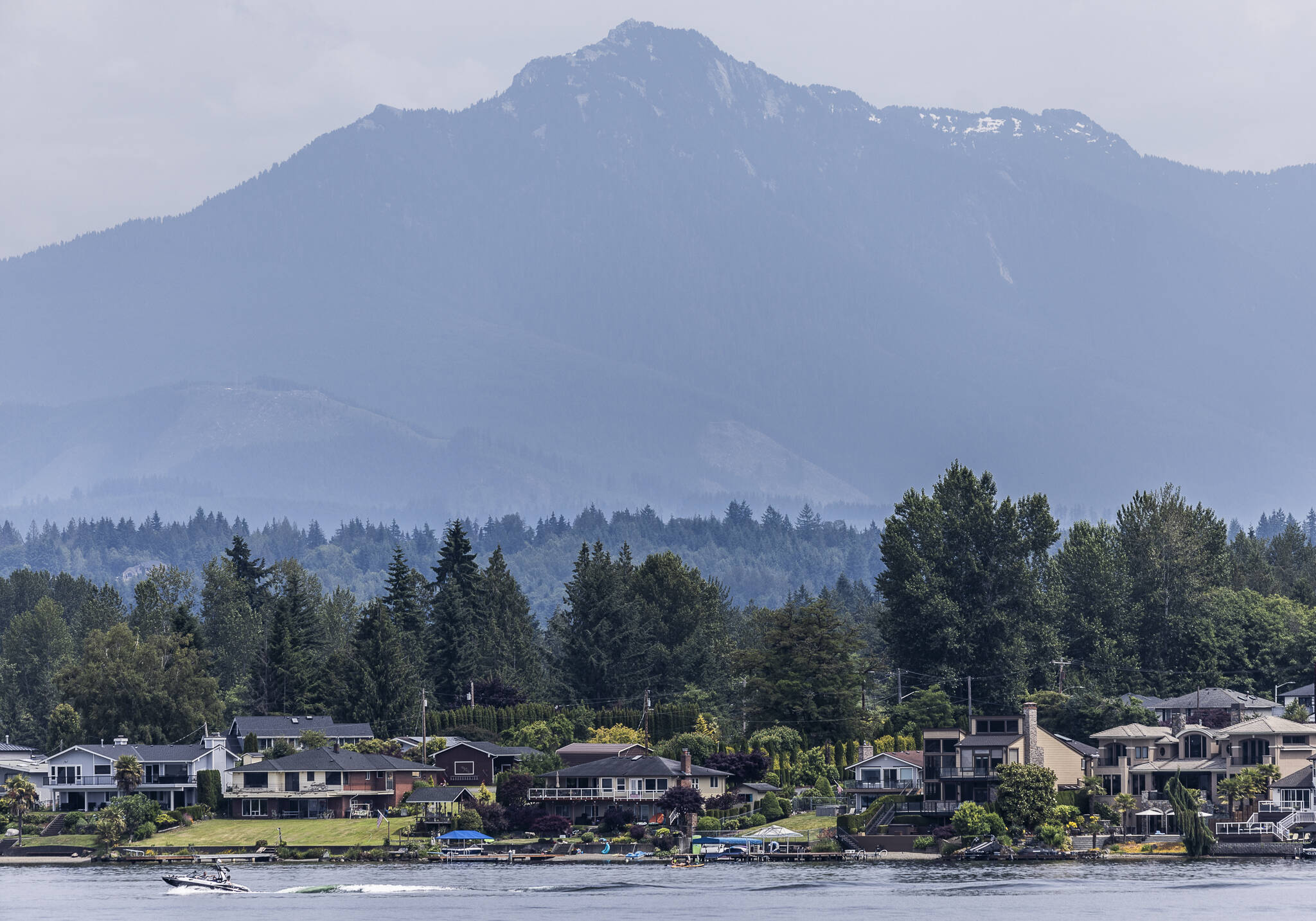 A boat sails along Lake Stevens with Mount Pilchuck visible in the background on Tuesday, June 24, 2025 in Lake Stevens, Washington. (Olivia Vanni / The Herald)