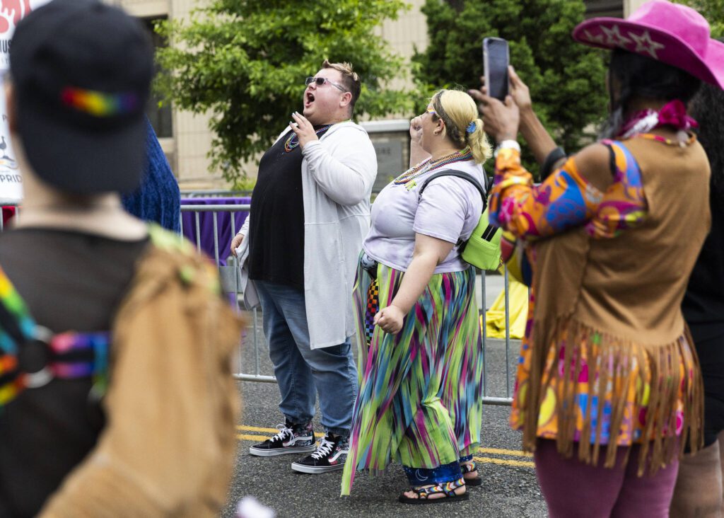 Brayden R., left, and Amelia Call, right, cheer on a drag performer during the Everett Pride Block Party on Saturday, June 21, 2025 in Everett, Washington. (Olivia Vanni / The Herald)
