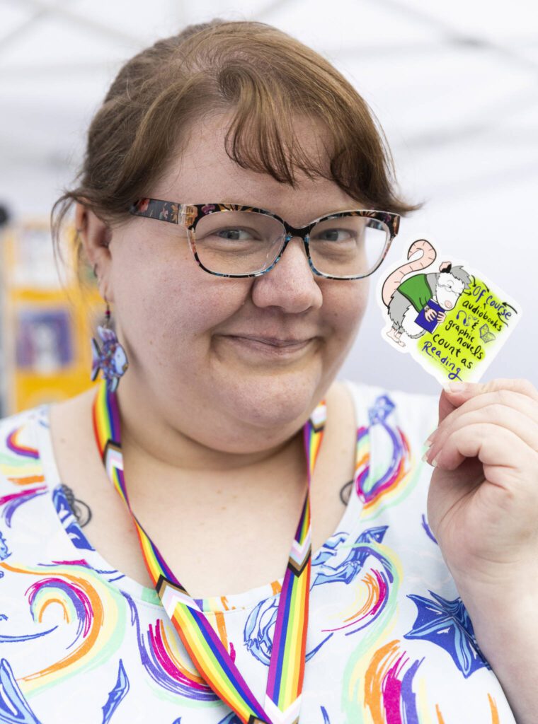 Jannah “Plex” Minnix poses with some of the art they created on stickers during the Everett Pride Block Party on Saturday, June 21, 2025 in Everett, Washington. (Olivia Vanni / The Herald)
