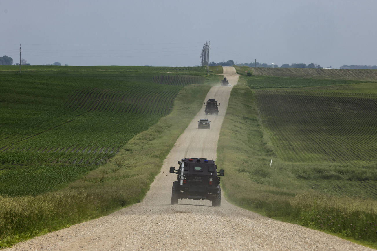 Minnesota State Patrol Special Response Team vehicles on a rural road during a manhunt for a man suspected of assassinating a Democratic state lawmaker and attempting to kill another, in Green Isle, Minn., on Sunday, June 15, 2025. A man suspected of assassinating a Minnesota lawmaker on Saturday and of shooting another was identified by the authorities as Vance Boelter, 57. (Tim Gruber/The New York Times)