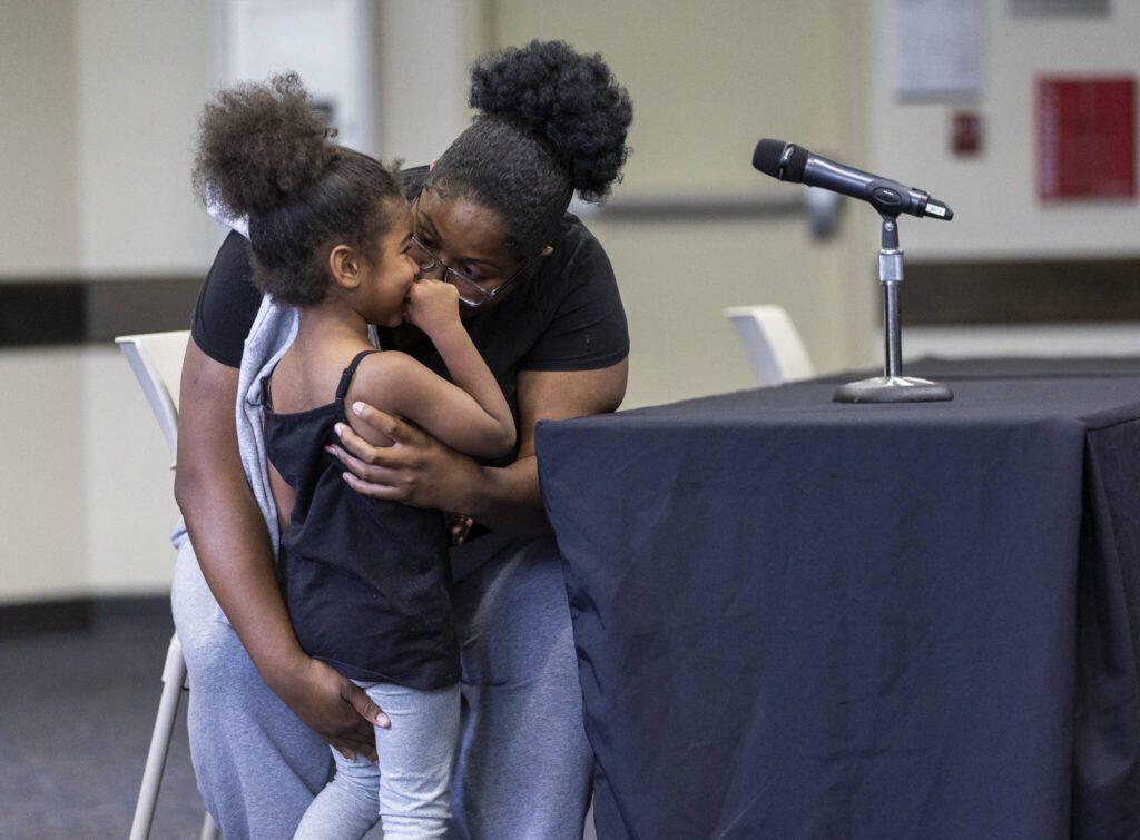 Aleena Richie talks with her daughter A’Mylah, 4, before she addresses the Everett Community College Board during a meeting on Thursday, June 26, 2025 in Everett, Washington. (Olivia Vanni / The Herald)
