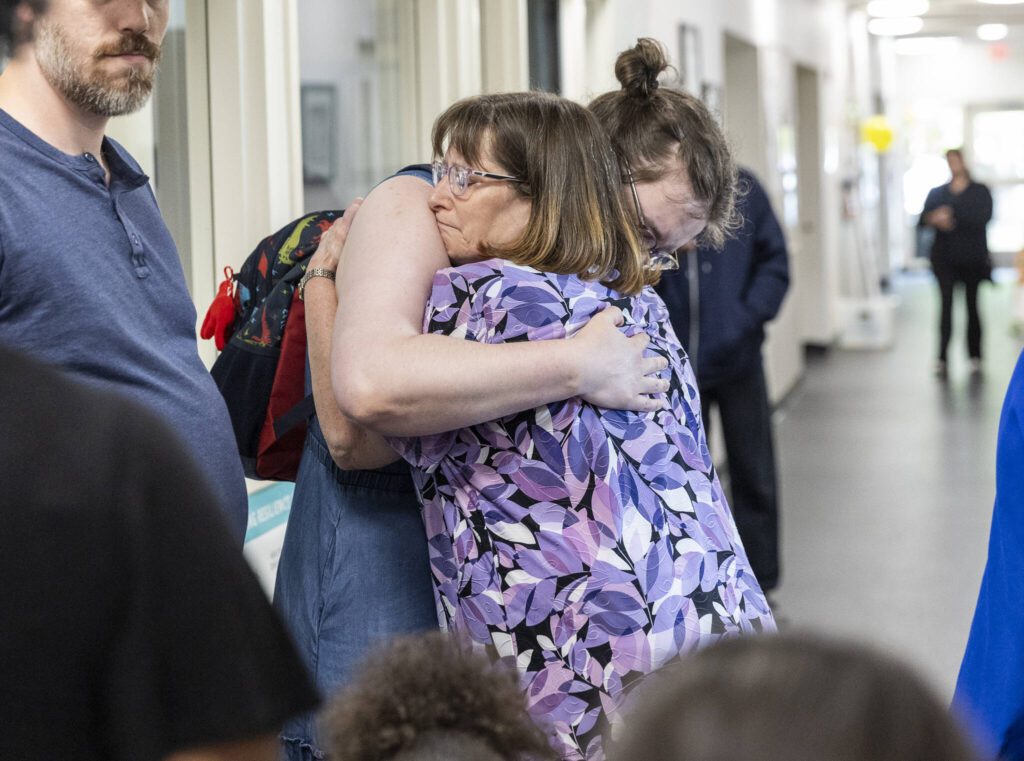 Teacher Pattie Fritts receives a hug from Early Learning Center students parent Stephanie Henifin on the last day of school on Wednesday, June 25, 2025 in Everett, Washington. (Olivia Vanni / The Herald)
