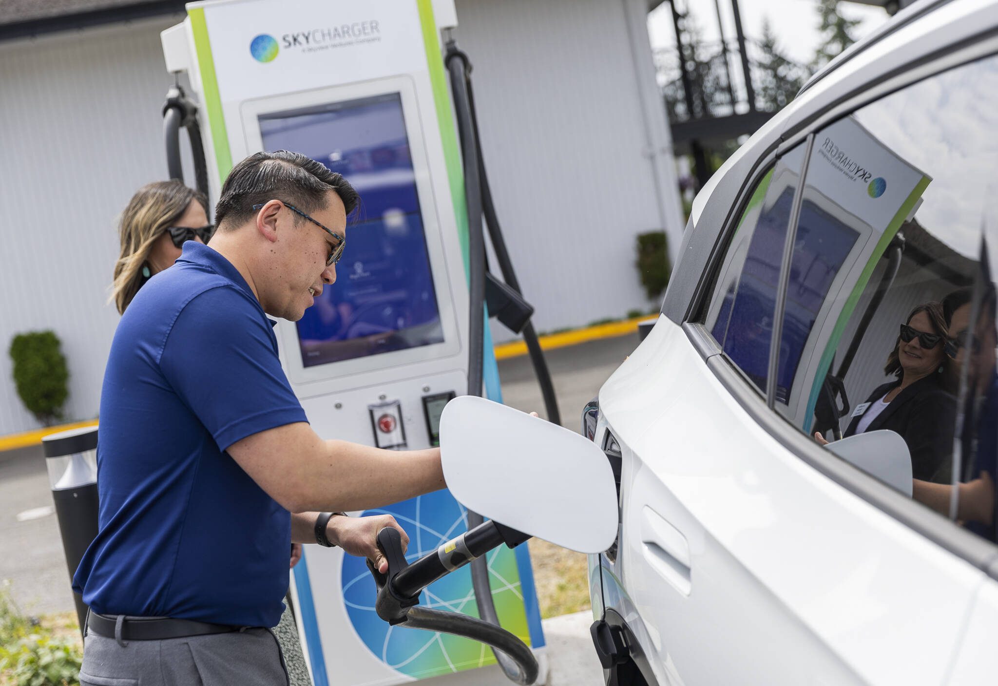 Commerce Director Joe Nguyễn plugs his car into one of the available Skycharger stations during the grand opening of the state’s first electric vehicle fast-charging station on Tuesday, June 24, 2025 in Arlington, Washington. (Olivia Vanni / The Herald)