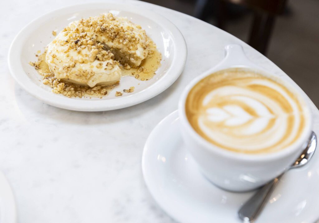 The Walrus crumpet with walnuts, ricotta and honey and a latte on Tuesday, June 24, 2025 in Edmonds, Washington. (Olivia Vanni / The Herald)
