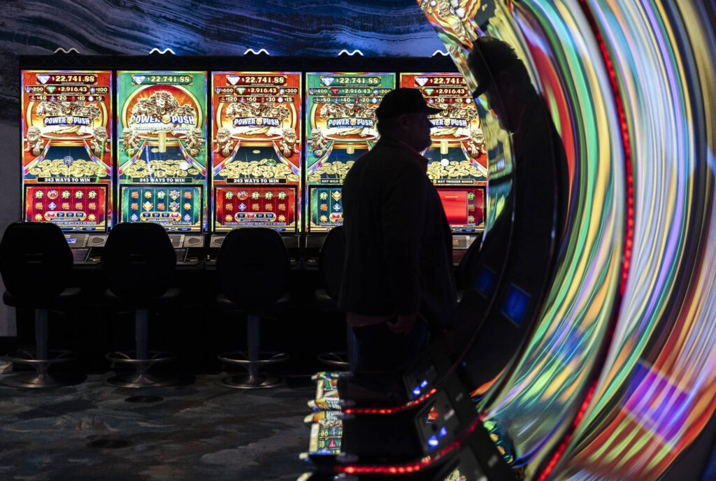 A person is silhouetted against slot machines during the opening of the Tulalip Resort Casino expansion on Thursday, July 3, 2025 in Tulalip, Washington. (Olivia Vanni / The Herald)
