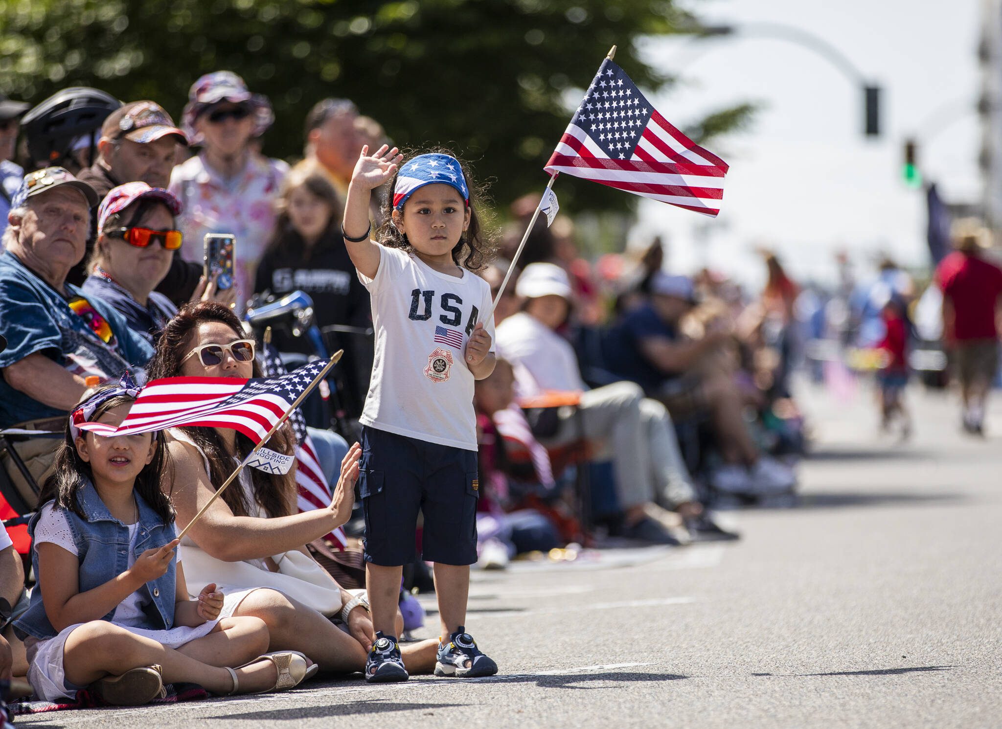 Liam Shakya, 3, waves at a float passing by during the Fourth of July parade on Friday, July 4, 2025 in Everett, Washington. (Olivia Vanni / The Herald)
