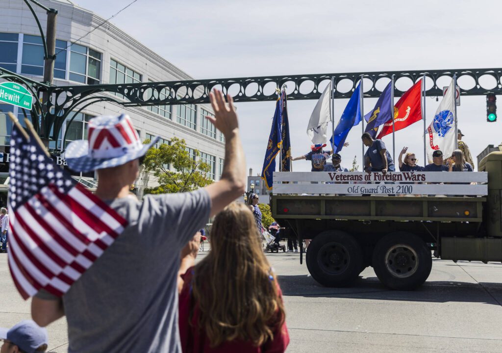 People waves at the Veterans of Foreign Wars float during the Fourth of July parade on Friday, July 4, 2025 in Everett, Washington. (Olivia Vanni / The Herald)
