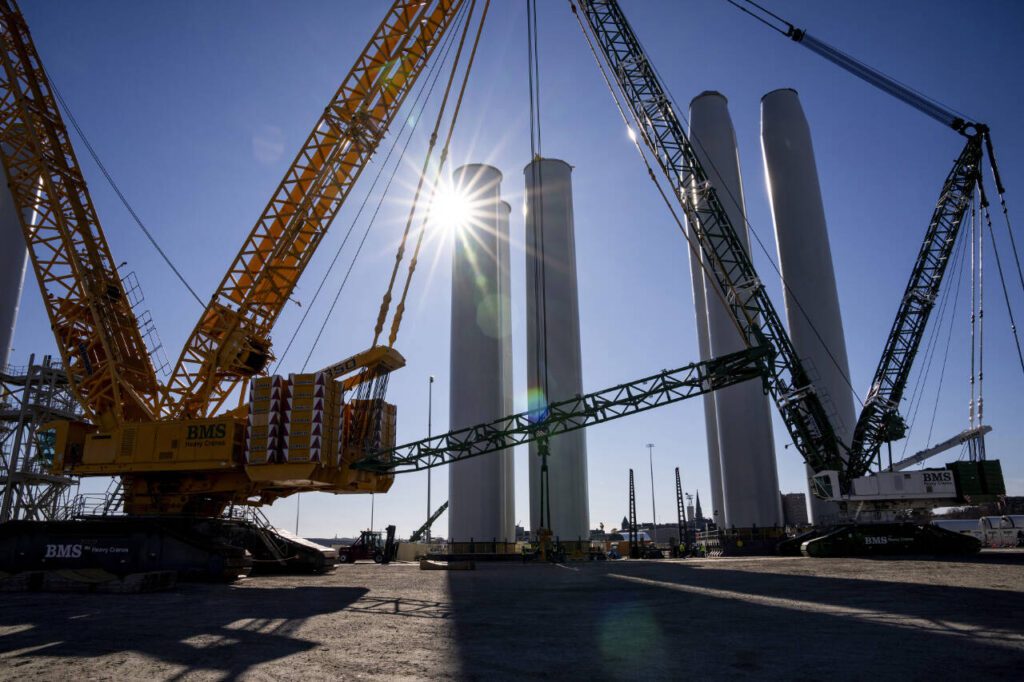Wind turbine tower sections, which will be transported vertically to the South Fork Wind site off Long Island in New York, are raised into place in New London, Conn., Nov. 20, 2023. By ending tax credits for wind and solar power, Senate Republicans have jeopardized billions in investments in their own districts. (Joe Buglewicz / The New York Times)

