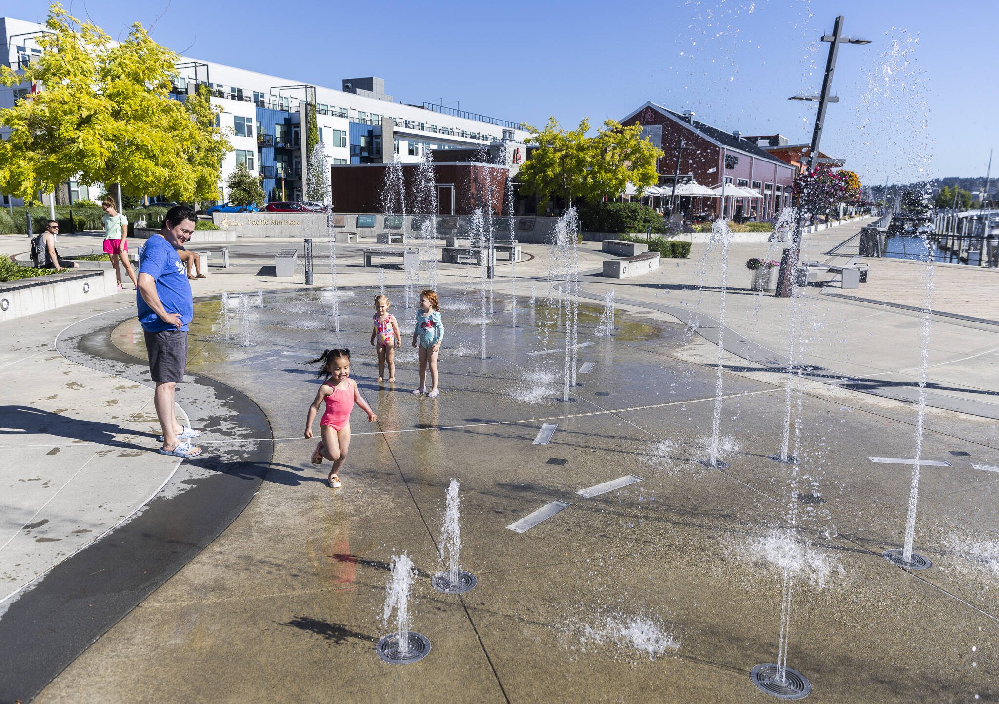 Skylar Maldonado, 2, runs through the water at Pacific Rim Plaza’s Splash Fountain, one of the newer features add to the Port of Everett waterfront on Tuesday, July 15, 2025 in Everett, Washington. (Olivia Vanni / The Herald)