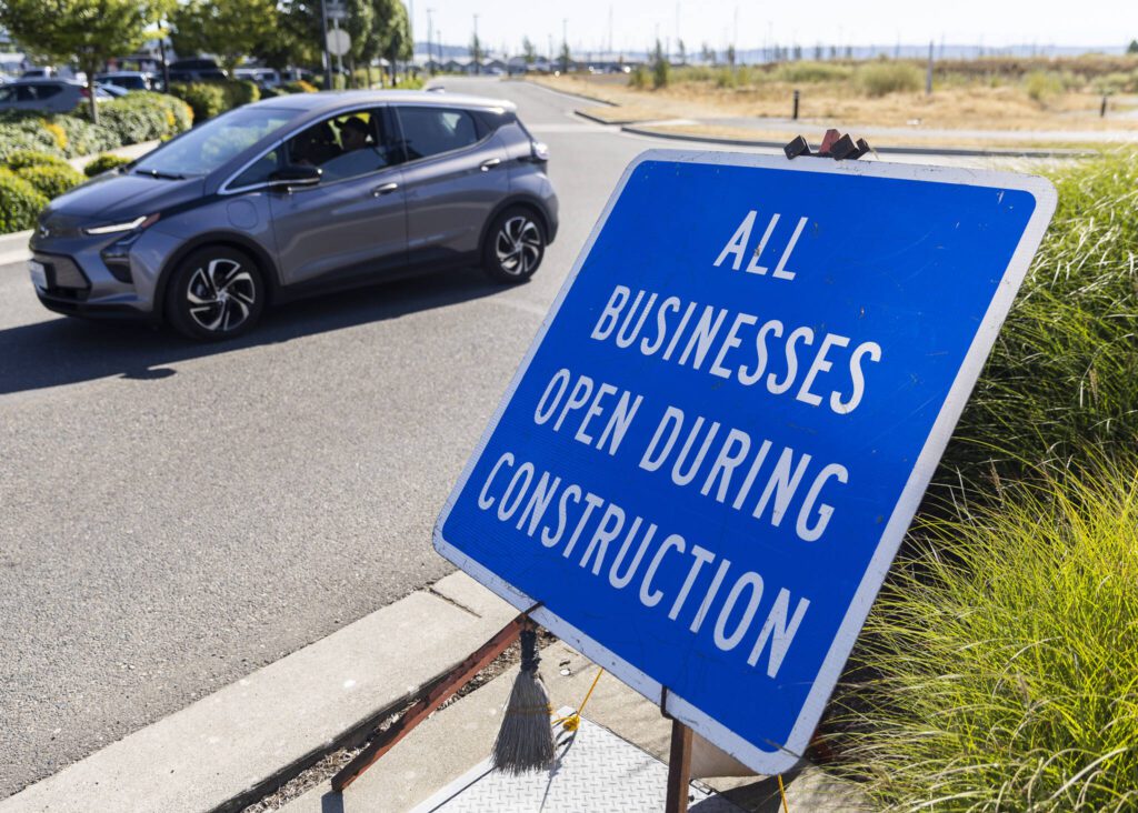 A sign alerts people that business are open during construction at the Port of Everett on Tuesday, July 15, 2025 in Everett, Washington. (Olivia Vanni / The Herald)
