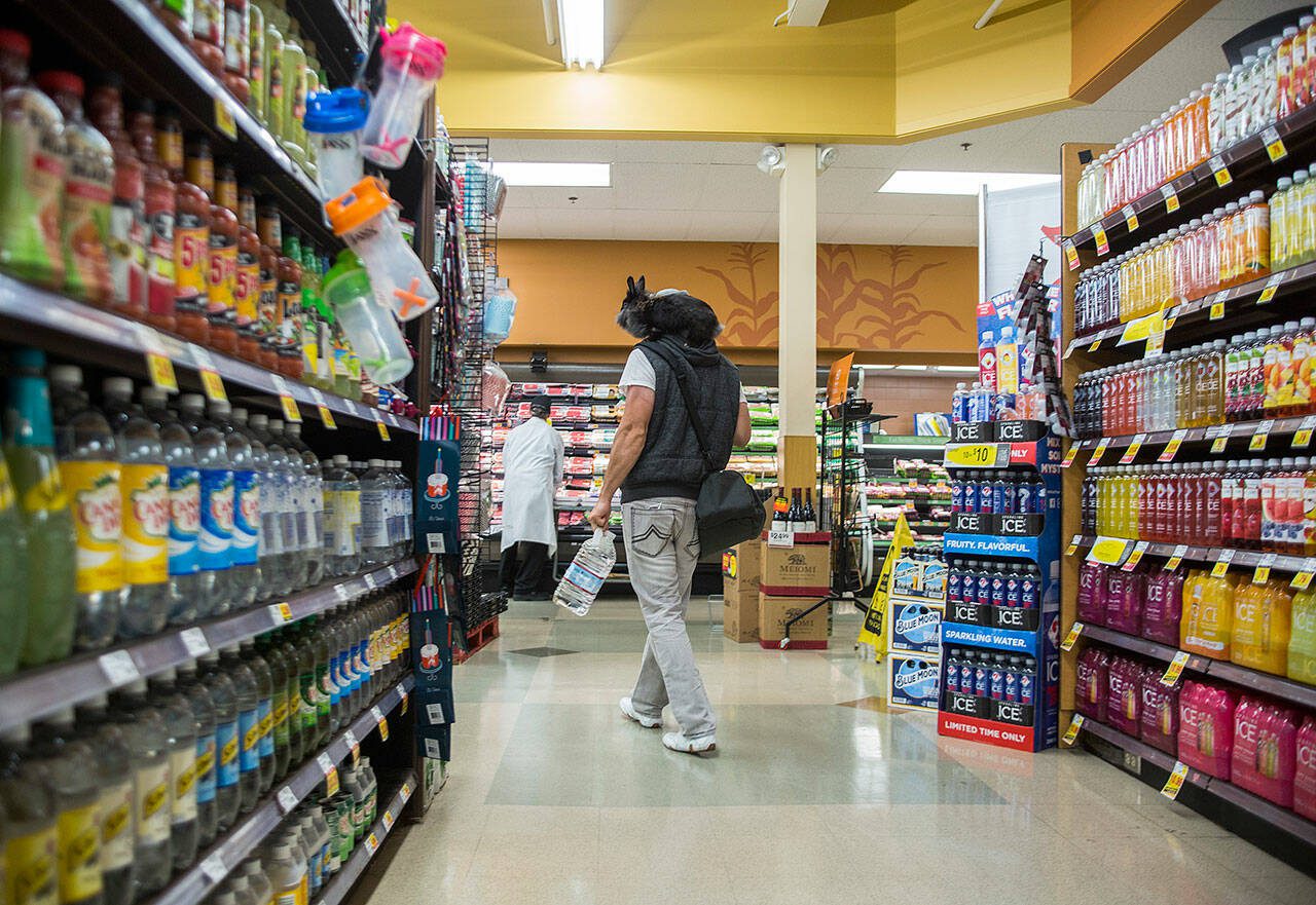 Ben Paul walks through a QFC store with Nala in 2018 in Everett, Washington. On Tuesday, a spokesperson for QFC’s parent company, The Kroger Co., confirmed the Mill Creek QFC will close its doors but said no firm date has been decided. (Olivia Vanni / The Herald)