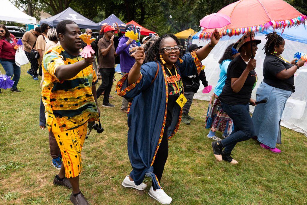 DanVonique Bletson-Reed, center, dances with community members during a second line parade honoring Marylin Quincy at the 33rd annual Nubian Jam on Saturday, July 26 at Forest Park in Everett, Washington. (Will Geschke / The Herald)
