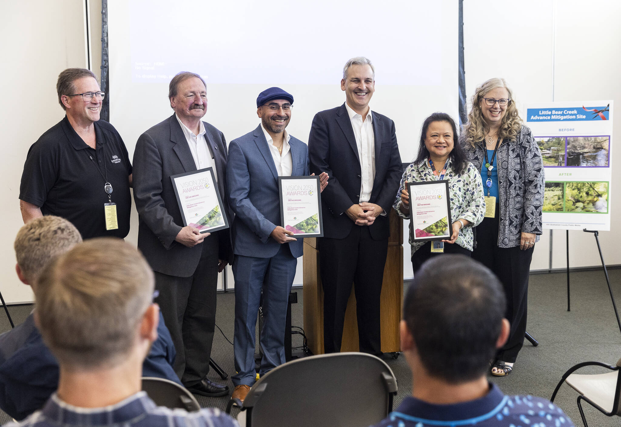 Doug McCormick (left to right), Dave Somers, Oscar Fuentes, Josh Brown, Clarissa Barrett and Kellie Snyder pose with Vision 2050 awards on Monday, July 28, 2025 in Everett, Washington. (Olivia Vanni / The Herald)