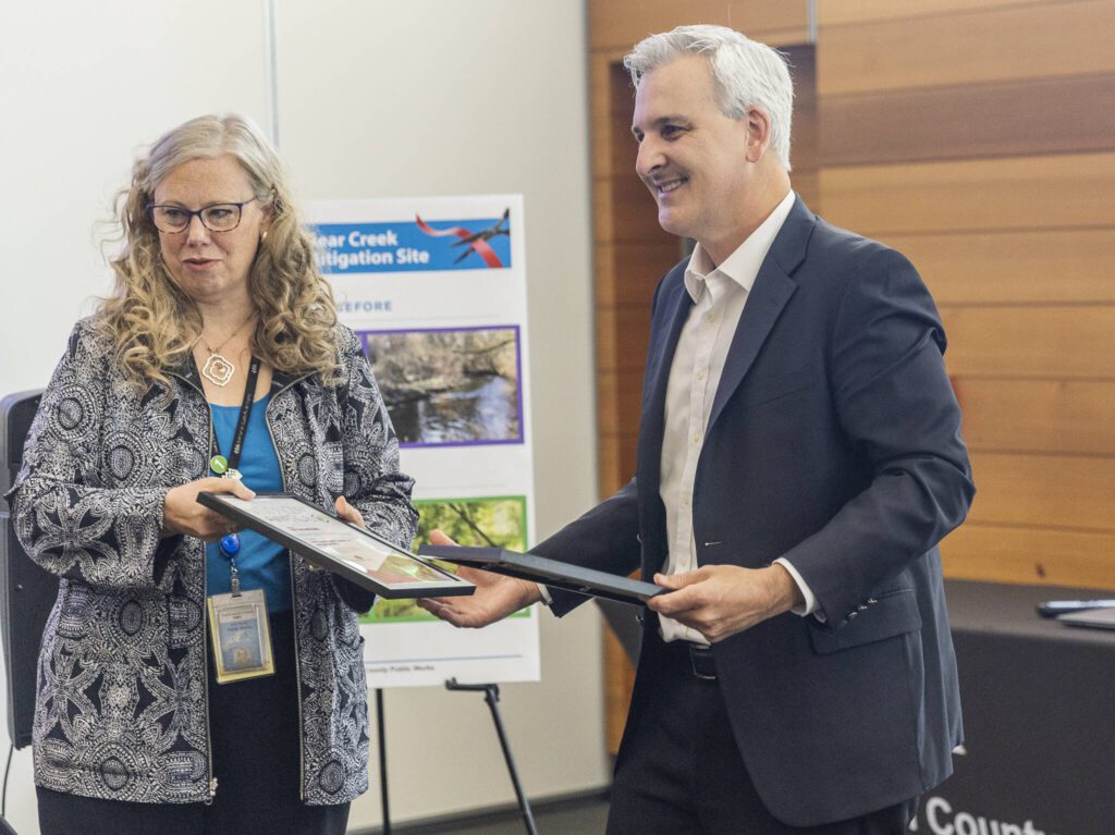 Public Works Director Kellie Snyder and Executive Director of the Puget Sound Regional Council Josh Brown hand out Vision 2050 awards for the Little Bear Creek Advance Mitigation Site on Monday, July 28, 2025 in Everett, Washington. (Olivia Vanni / The Herald)
