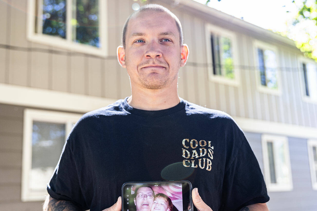 Jake Graham holds a photograph of his mother Poppy Graham on Monday, Aug. 11, 2025 in Everett, Washington. (Olivia Vanni / The Herald)