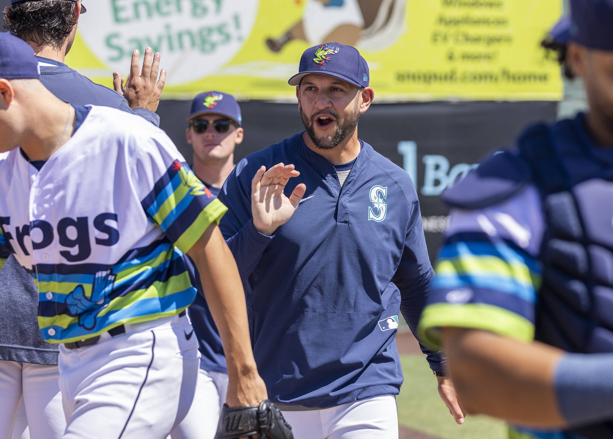 AquaSox pitching coach Matt Carasiti high-fives players before the start of a game on Thursday, July 24, 2025 in Everett, Washington. (Olivia Vanni / The Herald)