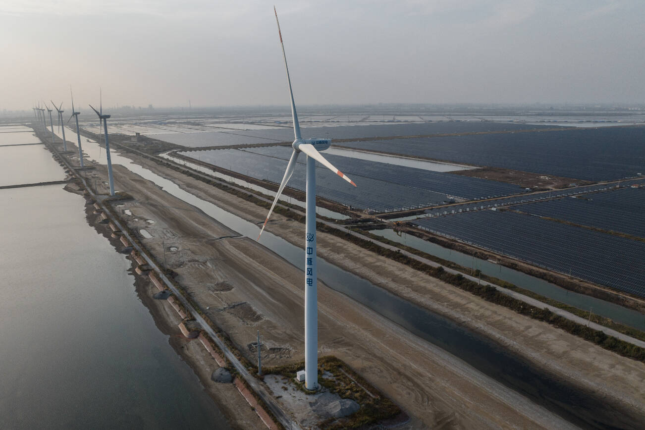 FILE — A coal-fired power plant and a wind turbine in Weifang, in Shandong Province, China, on Oct. 23, 2023. China installed more solar panels and wind turbines in 2024 than the rest of the world combined. (Gilles Sabrie/The New York Times)