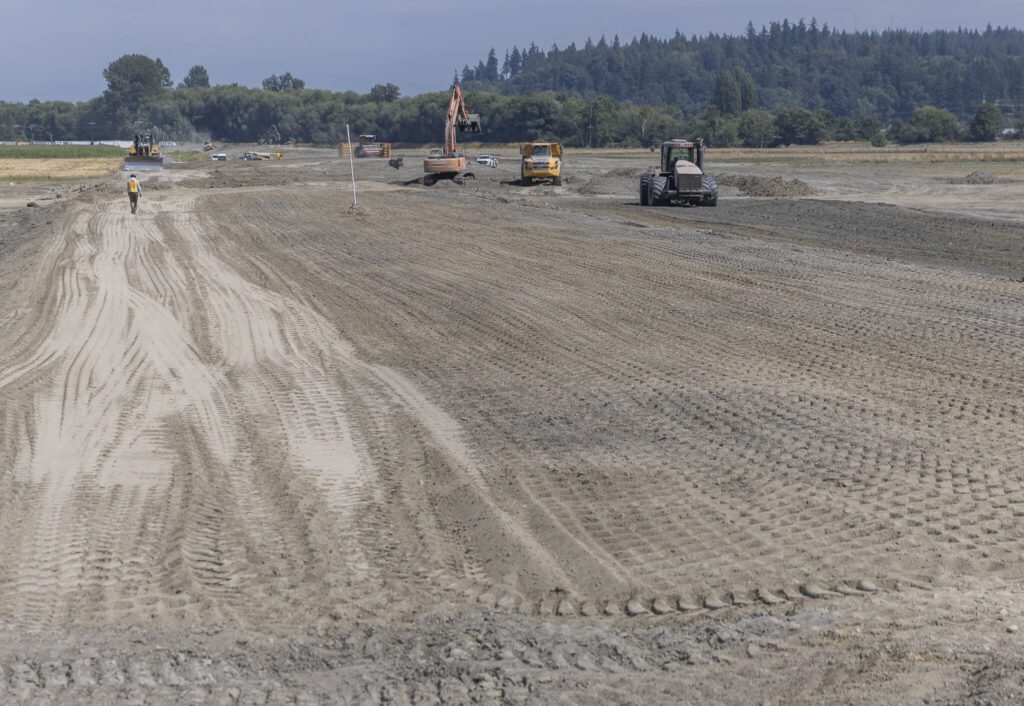 Construction vehicles work along what will be the new levy on Monday, Aug. 4, 2025 in Stanwood, Washington. (Olivia Vanni / The Herald)
