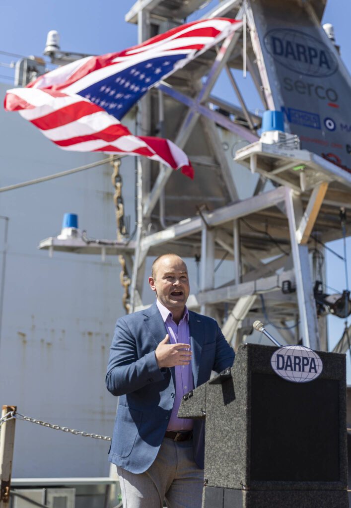 DARPA Director Stephen Winchell speaks at the christening of the USX-1 Defiant, a first-of-its-kind autonomous naval ship, at Everett Ship Repair on Monday, Aug. 11, 2025 in Everett, Washington. (Olivia Vanni / The Herald)
