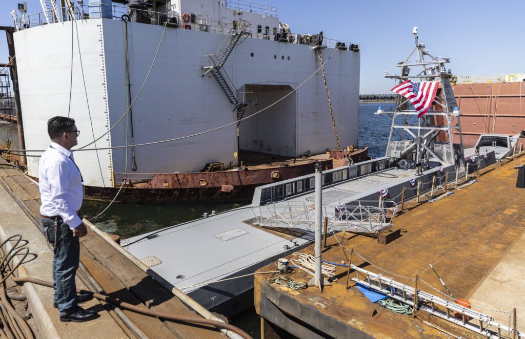 People look at the USX-1 Defiant, a first-of-its-kind autonomous naval ship, at Everett Ship Repair on Monday, Aug. 11, 2025 in Everett, Washington. (Olivia Vanni / The Herald)
