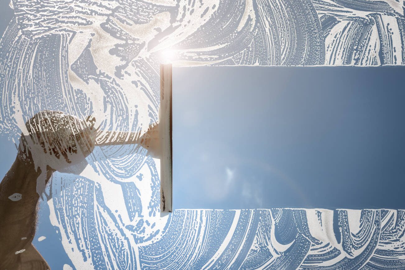Getty Images
Window cleaner using a squeegee to wash a window with clear blue sky