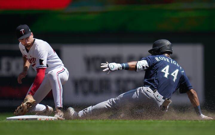 The Seattle Mariners' Julio Rodriguez slid safely into second on a double in the sixth inning against the Minnesota Twins as Edouard Julien tries to tag during a July 26, 2023 game at Target Field in Minneapolis, Minn. (Richard Tsong-Taatari, Star Tribune, Tribune News Services)