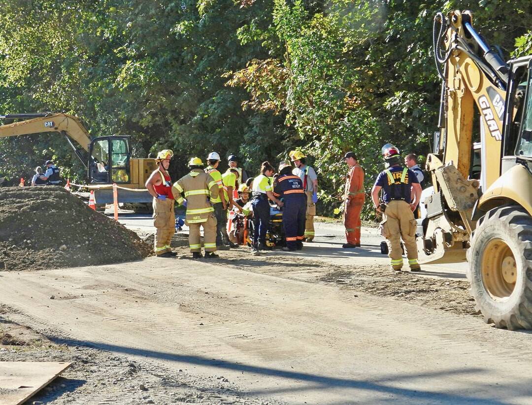 Paramedics and first responders attend to one of two injured workers at a worksite in 2024. Interpreters for the state Department of Labor and Industries serve those injured while working for an employer that is self-insured and does not participate in Washington’s workers’ compensation system. (Duck Paterson photo)