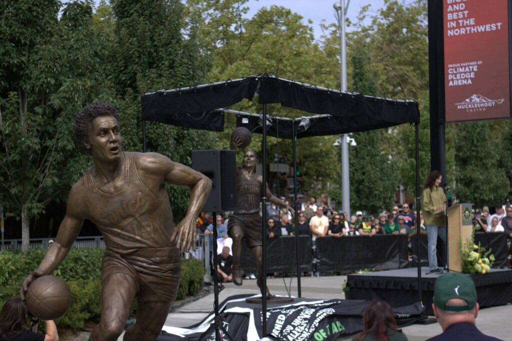 Seattle SuperSonics champion Lenny Wilkens’ statue is pictured alongside Seattle Storm Hall-of-Famer Sue Bird’s recently unveiled statue on Sunday, Aug. 17, 2025 outside of Climate Pledge Arena in Seattle. (Qasim Ali / The Herald)
