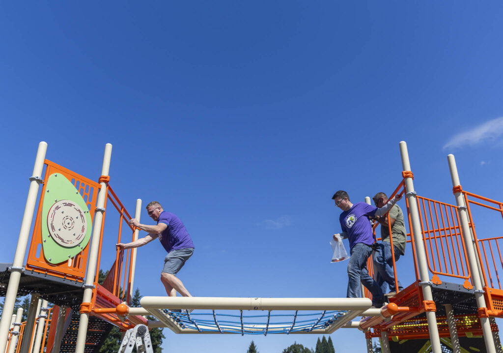 Travis Hammond, left, and Chris McGravey navigate their way across a play structure on Wednesday, Aug. 20, 2025 in Marysville, Washington. (Olivia Vanni / The Herald)
