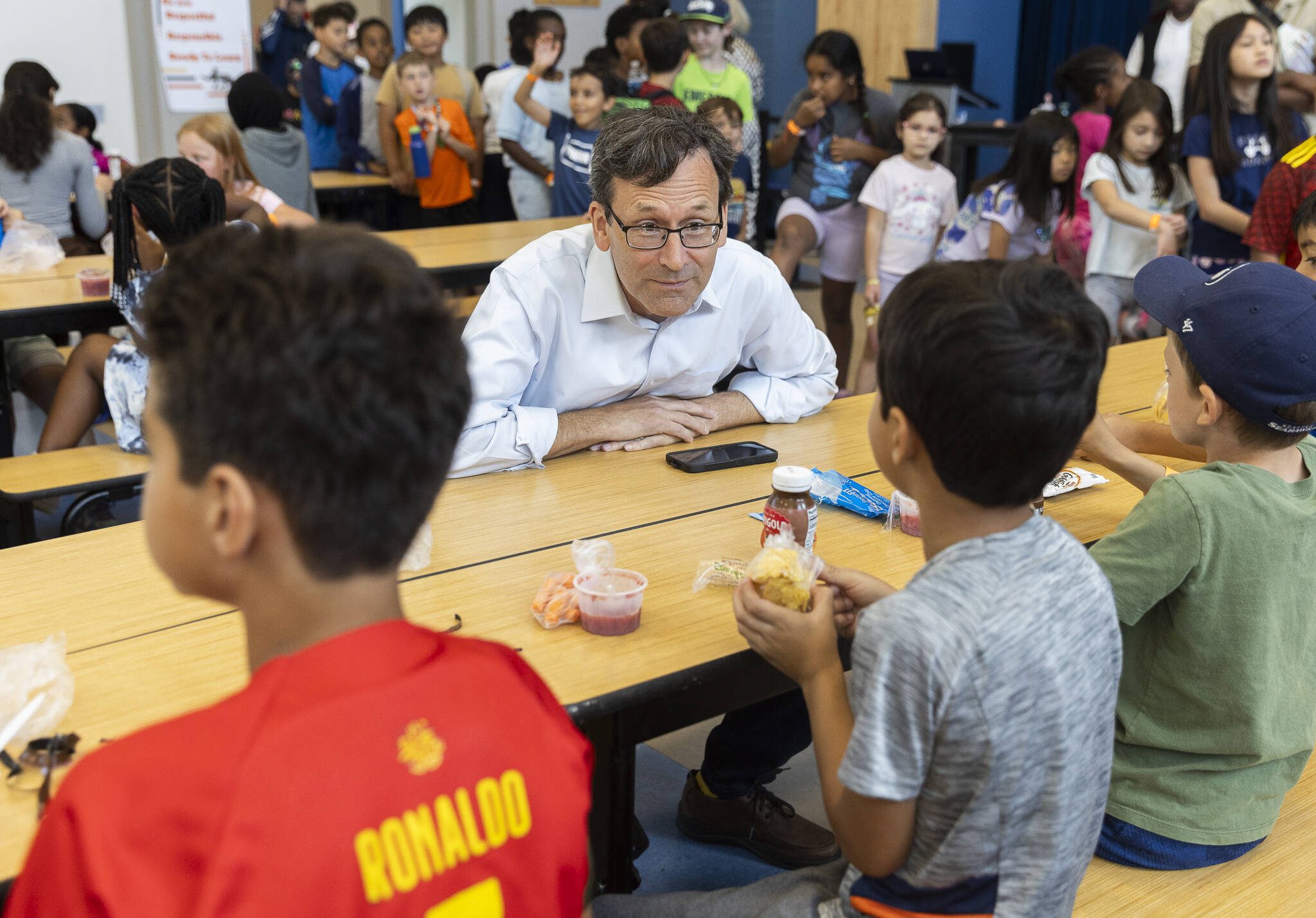 Gov. Bob Ferguson talks with kids at Lynnwood Elementary School during their lunch time on Thursday, Aug. 21, 2025 in Lynnwood, Washington. (Olivia Vanni / The Herald)