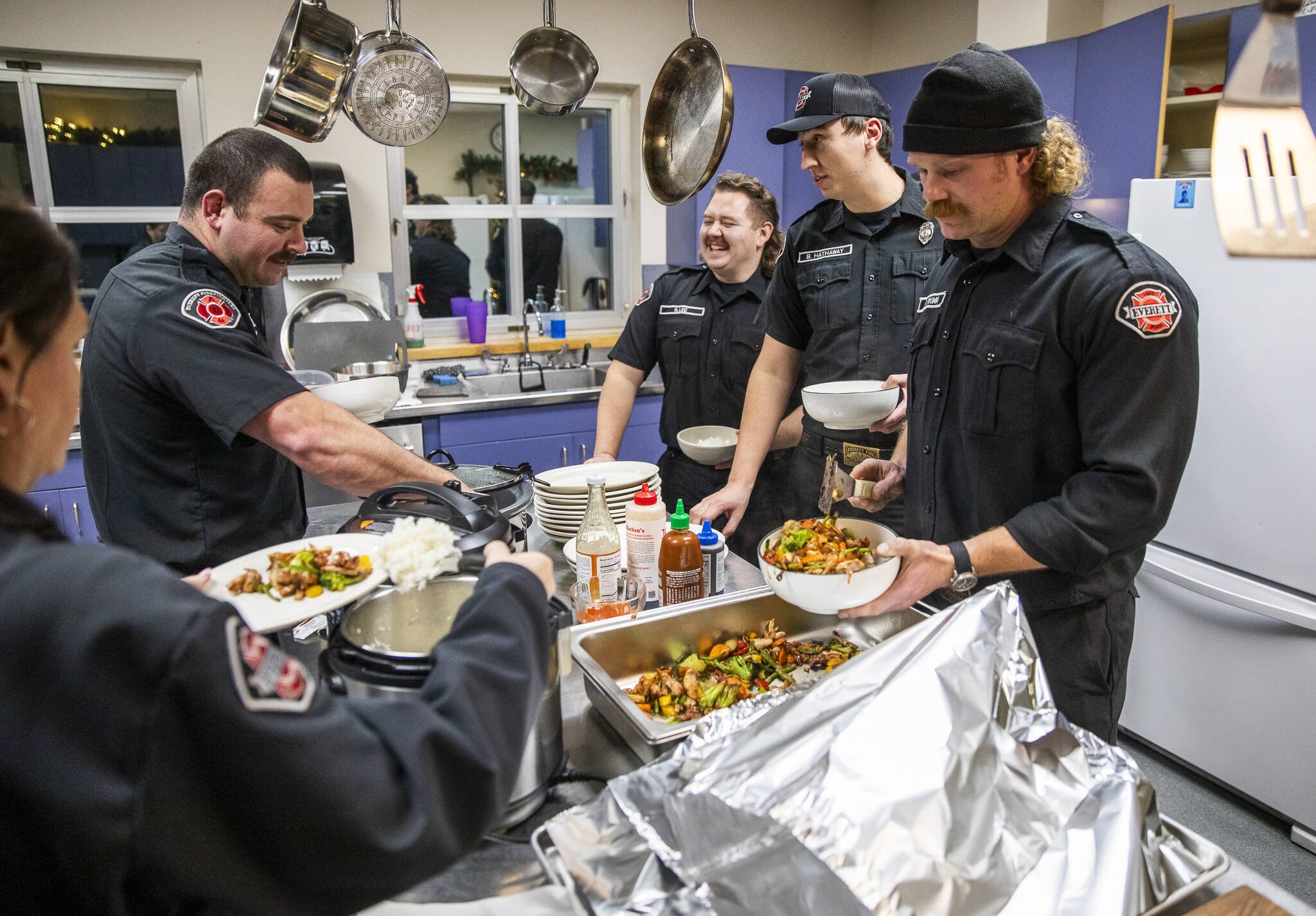 Firefighters at Everett Fire Station One dish up the dinner for 12 they prepared themselves. The fire crews rotate kitchen duty during their monthly shifts. Breaking to answer an emergency call is par for the course. (Olivia Vanni / The Herald)
Firefighters at Everett Fire Station One dish up the dinner for 12 they prepared themselves. The fire crews rotate kitchen duty during their monthly shifts. Breaking to answer an emergency call is par for the course. (Olivia Vanni / The Herald)
