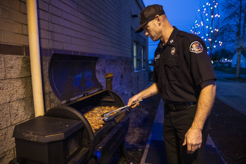 Todd Stark grills up chicken for Everett Fire Station One’s dinner. (Olivia Vanni / The Herald)
Todd Stark grills up chicken for Everett Fire Station One’s dinner. (Olivia Vanni / The Herald)
